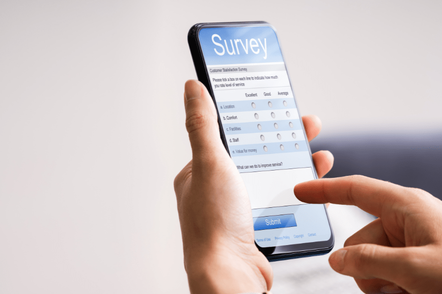 Image of an apartment tenant taking a satisfaction survey on a smartphone, an essential feedback tool for apartment managers.